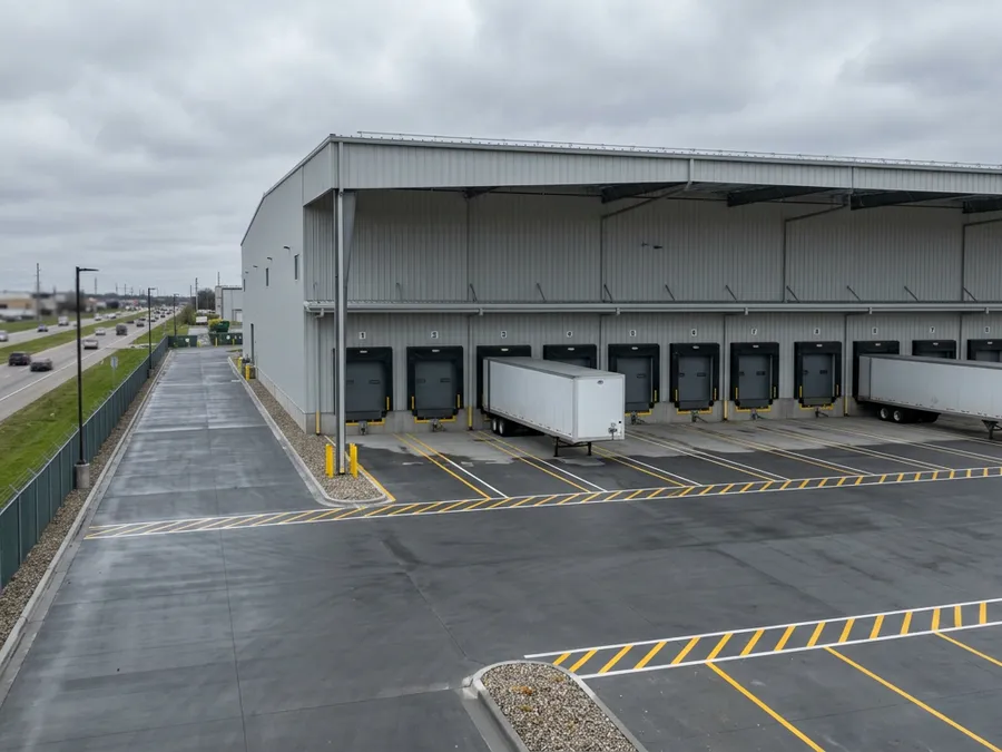 Pre-engineered steel warehouse with multiple loading docks and asphalt logistics yard